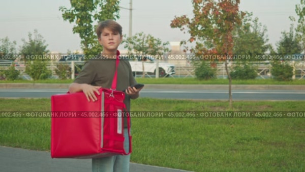 Child is compelled to work as a delivery courier, searching for a designated address in the urban environment to which he must deliver the goods. Стоковое видео, видеограф Strunov David / Фотобанк Лори