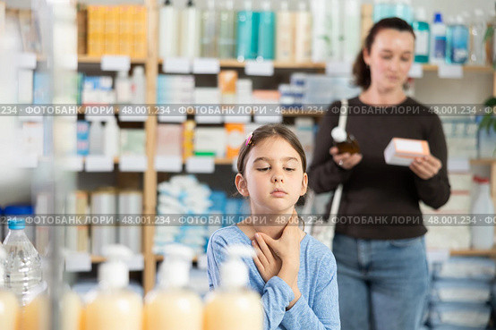 child stands and coughs in the pharmacy, and the mother chooses medications. Стоковое фото, фотограф Яков Филимонов / Фотобанк Лори