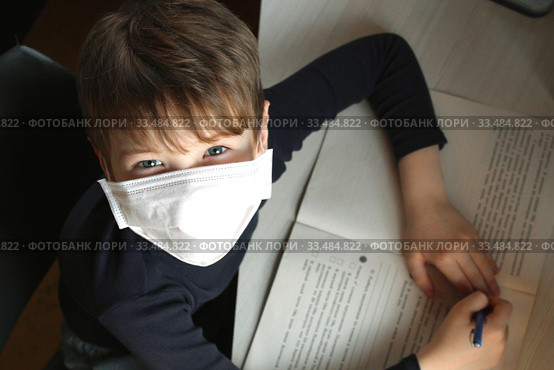 Child with antiviral mask doing his homework in quarantine. Стоковое фото, фотограф Попова Ольга / Фотобанк Лори