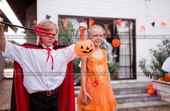 Children in ghost costumes are having fun trick-or-treating on Halloween. Стоковое фото, агентство Ingram Publishing / Фотобанк Лори