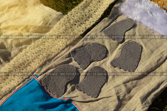Children's feet walk on an orthopedic massage diy mat with surfaces of various shapes and tactility. grass, cones, acorns - texture details. Prevention and treatment of flat feet. Стоковое фото, фотограф Ирина Старикова / Фотобанк Лори