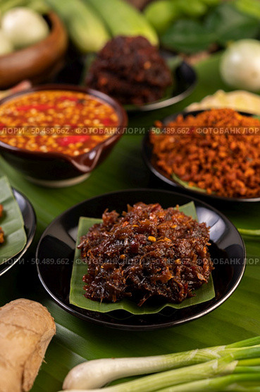 Chili paste is served on banana leaves on a plate with long beans, lime, chili, and eggplant. Стоковое фото, агентство Ingram Publishing / Фотобанк Лори
