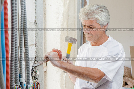 Chiseling away at a wall. Стоковое фото, агентство Ingram Publishing / Фотобанк Лори