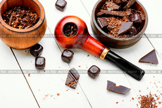 Chocolate flavored tobacco for smoking pipes.Tobacco pipe filled with tobacco.. Smoking pipe with tobacco leaves. Стоковое фото, агентство Ingram Publishing / Фотобанк Лори