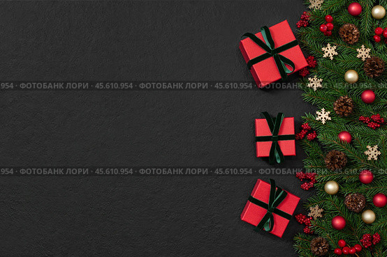 Christmas border with gifts, fir branches and festive decor on black background. New Year background with copy space. Top view, flat lay. Стоковое фото, фотограф Марина Багрова / Фотобанк Лори
