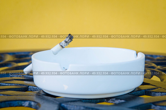 Cigarette smoldering in an ashtray in anticipation of the host. Стоковое фото, агентство Ingram Publishing / Фотобанк Лори