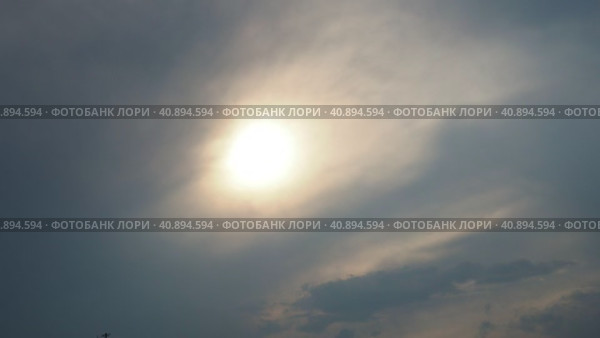 Cirrus clouds cover the disk of the sun with clouds. The disappearance of the sun behind thick dark clouds. Sunbeams in the haze. Sunset for Halloween. Weather forecast. Sky background. Стоковое видео, видеограф Юлия Петровская / Фотобанк Лори