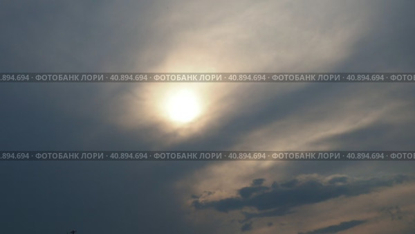 Cirrus clouds cover the disk of the sun with clouds. The disappearance of the sun behind thick dark clouds. Sunbeams in the haze. Sunset for Halloween. Weather forecast. Sky background. Стоковое видео, видеограф Юлия Петровская / Фотобанк Лори