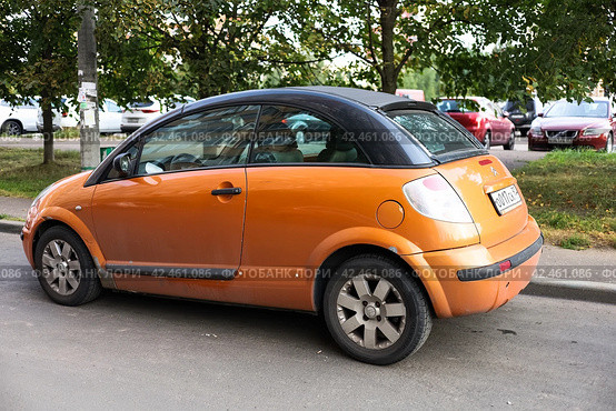 Citroen C3 Pluriel in orange color parked on the street. Pluriel can be configured as a hatchback with a multi-layer insulated top. Old convertible car produced by PSA Group. Редакционное фото, фотограф Константин Григорьев / Фотобанк Лори