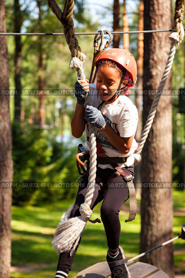 Climbing High in the Sky at an Exciting Outdoor Rope Park for Young Adventurers. Редакционное фото, фотограф Aleksandr Golubev / Фотобанк Лори