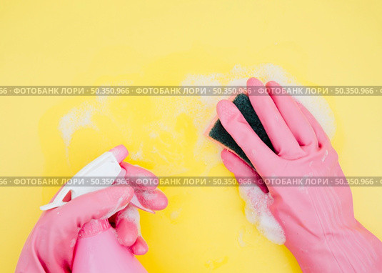 close up cleaner cleaning yellow backdrop with sponge spray bottle. Стоковое фото, агентство Ingram Publishing / Фотобанк Лори