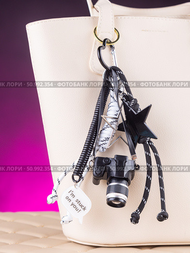 Close-up of a collection of black keychains shaped like cameras, complemented by decorative cords and beads. Стоковое фото, фотограф Виталий Сова / Фотобанк Лори
