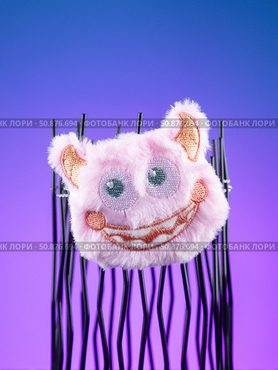 Close-up of a fluffy pink monster plush with a cheerful smile and adorable horn-like ears. Стоковое фото, фотограф Виталий Сова / Фотобанк Лори