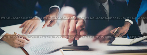 Close-up Of A Person’s Hand Stamping With Approved Stamp On Document At Desk, management approval banner background. Стоковое фото, агентство Ingram Publishing / Фотобанк Лори