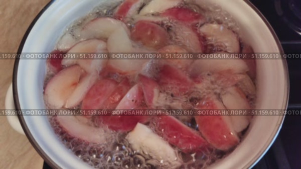 Close-up of apples boiling in a pot with water. The process of making homemade fruit compote from fresh apples. Boiling, bubbles on the surface, natural food and a cozy kitchen atmosphere. Стоковое видео, видеограф Андрей Жигальцов / Фотобанк Лори