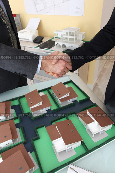 Close-up of architects shaking hands. Стоковое фото, агентство Ingram Publishing / Фотобанк Лори