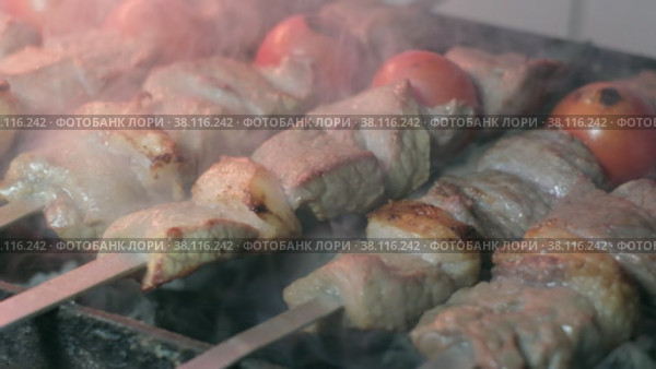 Close-up of lumpy kebab with tomato and ground kebab is grilled on the grill. Стоковое видео, видеограф Aleksey Kidisyuk / Фотобанк Лори