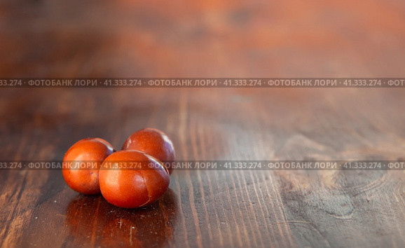 Close-up of ripe delicious ziziphus berries (impossible, Chinese date berry) on a wooden table selective focus shallow depth of field free space for text and design. Brown fruits crack from ripeness. Стоковое фото, фотограф Александр Кротков / Фотобанк Лори