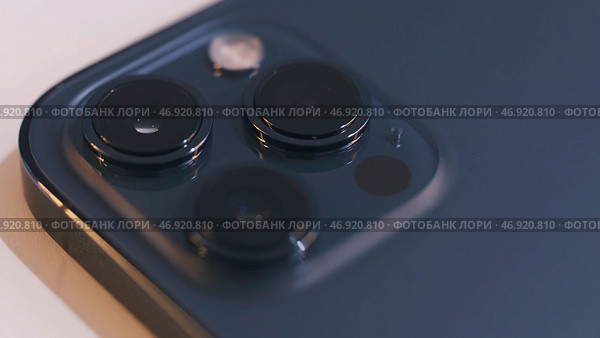 Close up of three cameras of a beautiful blue smartphone isolated on white background. Редакционное фото, фотограф David Kashakhi / Фотобанк Лори