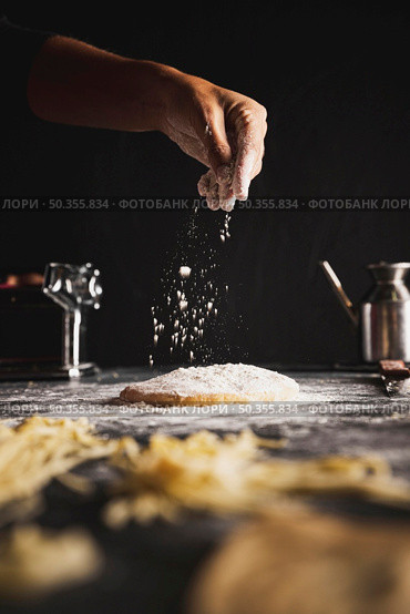 close up person sprinkling flour dough. Стоковое фото, агентство Ingram Publishing / Фотобанк Лори