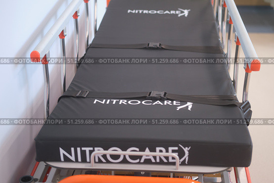 Close up view of empty hospital gurney Nitrocare with black mattress and safety straps. Medical transport concept for patient care and emergencies - Moscow, Russia, September 06, 2025. Редакционное фото, фотограф Андрей Журавлев / Фотобанк Лори