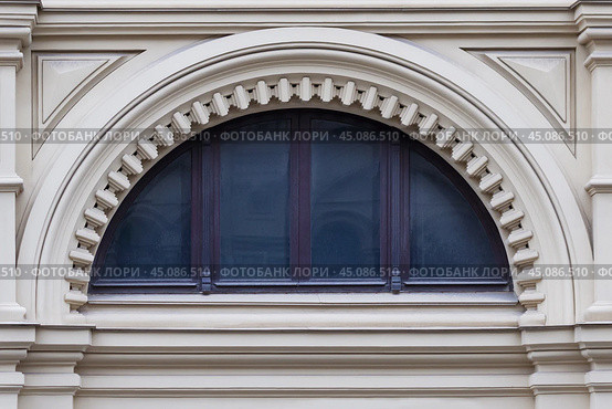 Close up view on a  semicircular window on a facade of white stone ancient building with carved decor. Стоковое фото, фотограф Михаил Строгалев / Фотобанк Лори
