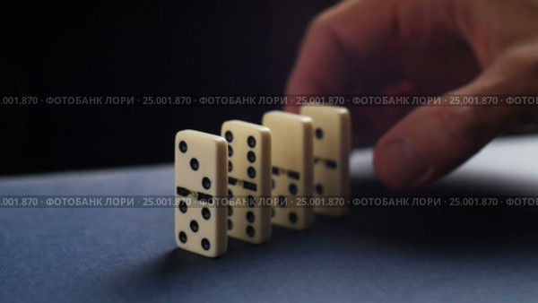 Closeup of a hand putting a domino. Dominoes falling. Nervous and failure. Стоковое видео, видеограф Сергей Кальсин / Фотобанк Лори
