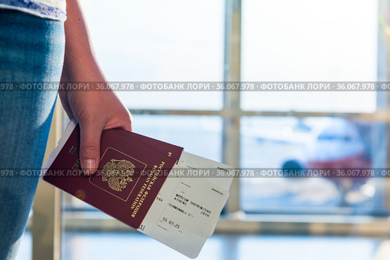 Closeup of female holding passports and boarding pass at airport. Стоковое фото, фотограф Константин Лабунский / Фотобанк Лори