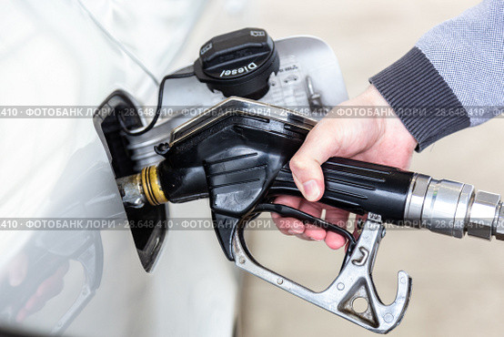 Closeup of mans hand pumping gasoline fuel in car at gas station. Стоковое фото, фотограф Matej Kastelic / Фотобанк Лори