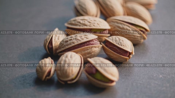 Closeup of pistachios rolling on textured surface in natural light. Стоковое AI-видео, аниматор Башкирова Анна / Фотобанк Лори