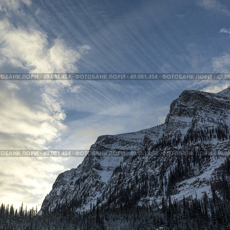 Cloud streaked sky over mountain top, Lake Louise, Banff National Park, Alberta, Canada. Стоковое фото, агентство Ingram Publishing / Фотобанк Лори