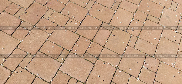 Cobbled street of the old city, lined with square and rectangular stone tiles in a chaotic manner. Soft beige or yellow colors and tones. The texture of the stone. Geometric pattern. Стоковое фото, фотограф Юлия Петровская / Фотобанк Лори