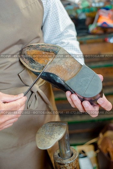 Cobbler scraping sole of shoe with a knife. Стоковое фото, агентство Ingram Publishing / Фотобанк Лори