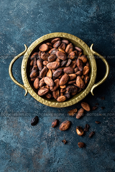 Cocoa beans on dark background, top view, copy space, flat lay. Стоковое фото, агентство Ingram Publishing / Фотобанк Лори