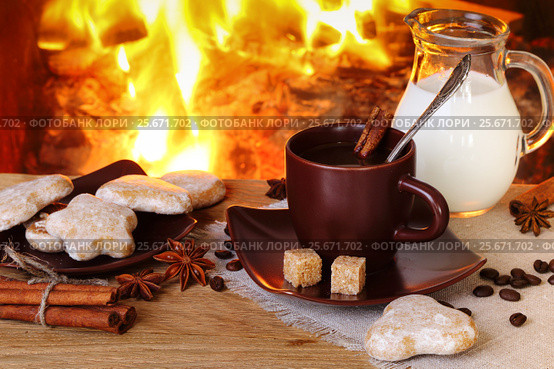 Coffee with spices, milk and cakes on the background of a burning fireplace. Стоковое фото, фотограф Феликс Хромых / Фотобанк Лори