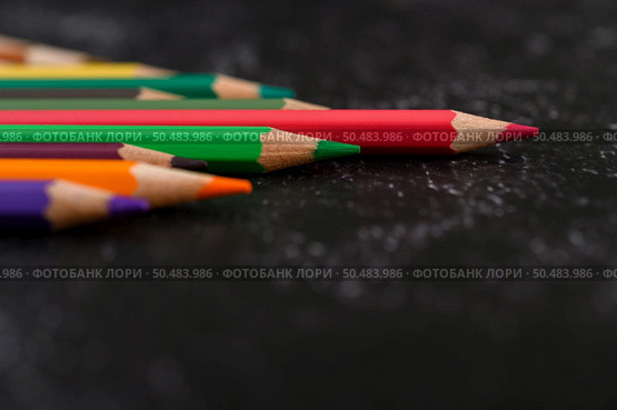 colorful crayon pencils with triangle shape on black background with copy space. Selective focus. Стоковое фото, агентство Ingram Publishing / Фотобанк Лори