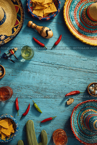 Colorful Fiesta Celebration Layout Featuring Hats, Snacks, and Drinks on Blue Wooden Table. Стоковое AI-изображение, AI-художник Юлия Гапеенко / Фотобанк Лори