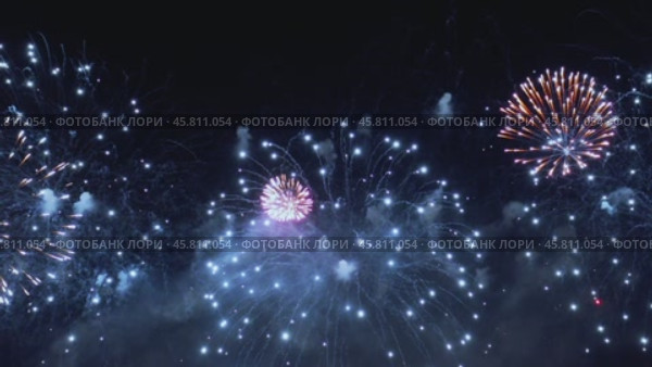 Colorful fireworks exploding in the night sky. Celebrations and events in bright colors. Стоковое видео, видеограф Андрей Армягов / Фотобанк Лори