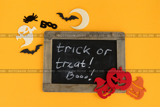 Colorful halloween scene. Trick and treat letters on blackboard with colorful halloween pumpkins, bats and ghoste. Стоковое фото, агентство Ingram Publishing / Фотобанк Лори