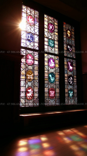Colorful stained glass window casting vibrant reflections in an indoor space during afternoon sunlight. Стоковое AI-изображение, AI-художник Сергей Толмачёв / Фотобанк Лори