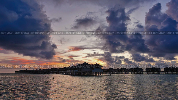Colorful sunset over the Black Sea. The sun disappeared. There are purple clouds in the blue sky. An orange glow above the horizon. Shadows and highlights on the water. Waves foaming on a pebble beach. Стоковое фото, фотограф Вера Ивановна Кубарева / Фотобанк Лори