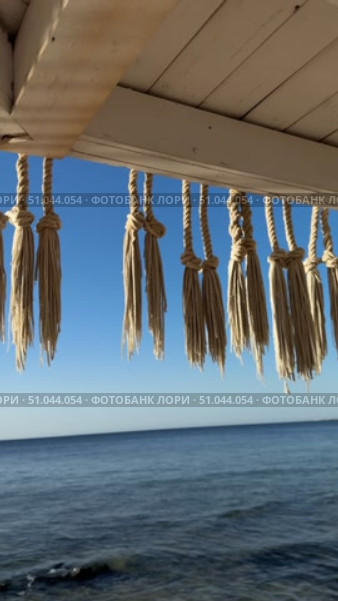 Concept of travel, seascape and nature tropical beach with palm tree and two sun loungers wooden sun loungers on the sea Welcoming beach cafe with straw parasols.Breezy summer day under straw sun umbrellas and beachfront view on Azure restaurant with straw umbrellas. Стоковое видео, видеограф Zita Khasanova / Фотобанк Лори
