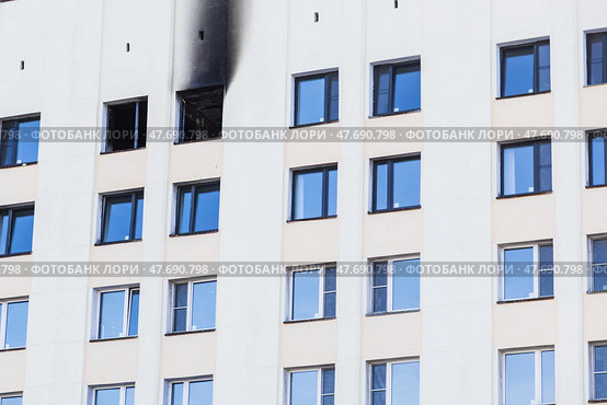 Consequences of a fire on the facade of a multi-story building. An open window with traces of soot. Последствия пожара в многоэтажном доме. Открытое окно со следами гари на стене. Стоковое фото, фотограф Наталья Василькова / Фотобанк Лори