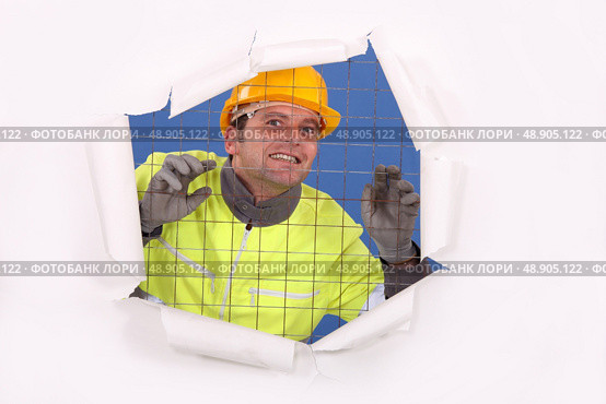 Construction worker behind wire fence. Стоковое фото, агентство Ingram Publishing / Фотобанк Лори