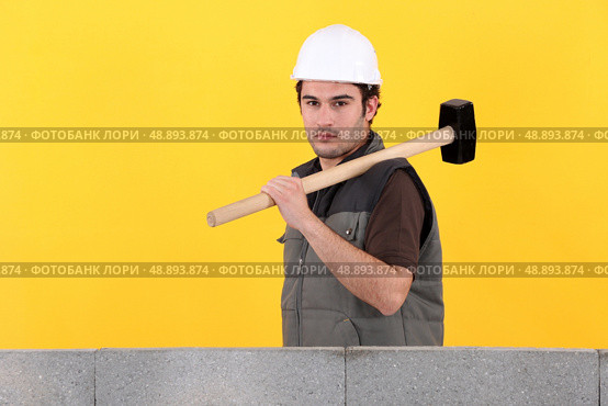 Construction worker holding a mallet. Стоковое фото, агентство Ingram Publishing / Фотобанк Лори