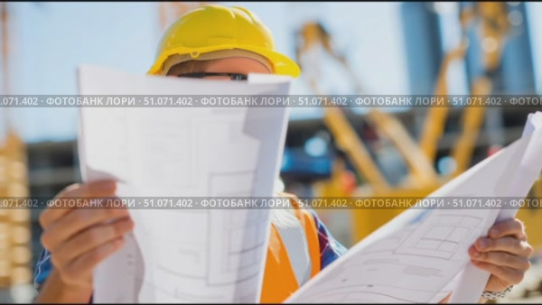 Construction worker reviews plans at job site during bright sunny day. Стоковое AI-видео, аниматор Сергей Толмачёв / Фотобанк Лори