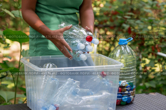 Container of plastic bottles. Garbage collection around the world. Clean the planet of plastic garbage. Ecology. A woman sorts garbage. Стоковое фото, фотограф Photojuli / Фотобанк Лори