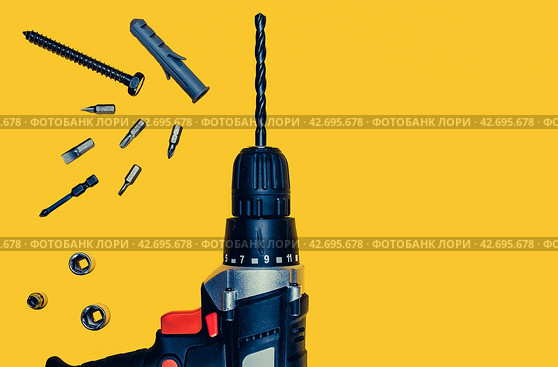 Cordless drill, screwdriver with drills of different sizes on yellow background. Repair and renovation concept. Repair tools for house constructor. Flat lay composition. Стоковое фото, фотограф Константин Григорьев / Фотобанк Лори