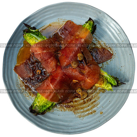 Cores of garden green salad are laid out on plate, baked with slices of fatty pork bacon. Стоковое фото, фотограф Яков Филимонов / Фотобанк Лори