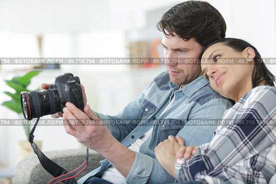 couple at home reviewing photos on camera screen. Стоковое фото, агентство Ingram Publishing / Фотобанк Лори